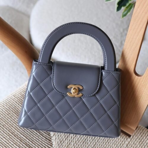 The Chanel Mini Kelly 23K in durable caviar calfskin leather boasts a rigid, compact square form with iconic quilting and antique gold CC turn-lock. Opt for hand carry with the fixed top handle or crossbody via the chain-and-leather strap. Its leather interior includes a zip pocket and slip pocket, holding iPhone 14 Pro, cards, and keys. Sleek with no back pocket, it's a versatile nano essential for everyday Chanel sophistication in Dubai.