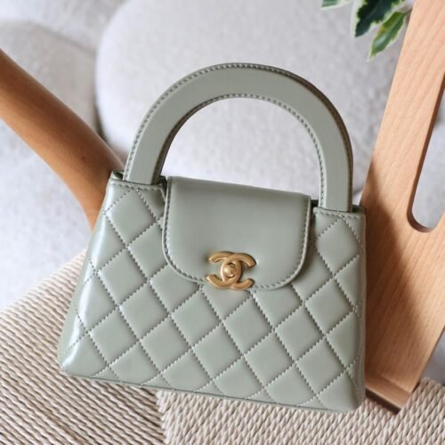 The Chanel Mini Kelly 23K in durable caviar calfskin leather boasts a rigid, compact square form with iconic quilting and antique gold CC turn-lock. Opt for hand carry with the fixed top handle or crossbody via the chain-and-leather strap. Its leather interior includes a zip pocket and slip pocket, holding iPhone 14 Pro, cards, and keys. Sleek with no back pocket, it's a versatile nano essential for everyday Chanel sophistication in Dubai.