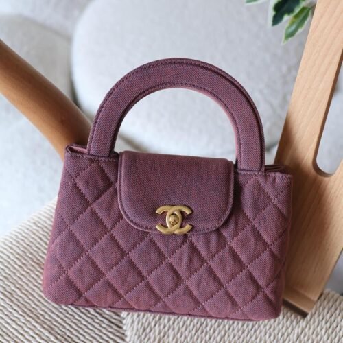 The Chanel Mini Kelly 23K in durable caviar calfskin leather boasts a rigid, compact square form with iconic quilting and antique gold CC turn-lock. Opt for hand carry with the fixed top handle or crossbody via the chain-and-leather strap. Its leather interior includes a zip pocket and slip pocket, holding iPhone 14 Pro, cards, and keys. Sleek with no back pocket, it's a versatile nano essential for everyday Chanel sophistication in Dubai.