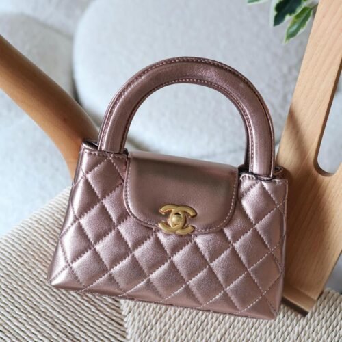 The Chanel Mini Kelly 23K in durable caviar calfskin leather boasts a rigid, compact square form with iconic quilting and antique gold CC turn-lock. Opt for hand carry with the fixed top handle or crossbody via the chain-and-leather strap. Its leather interior includes a zip pocket and slip pocket, holding iPhone 14 Pro, cards, and keys. Sleek with no back pocket, it's a versatile nano essential for everyday Chanel sophistication in Dubai.